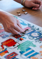Person assembling a colorful puzzle on a wooden table