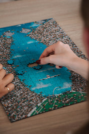 Person assembling a Epic Bokke MasterPiece 3mm wooden puzzle on a table.