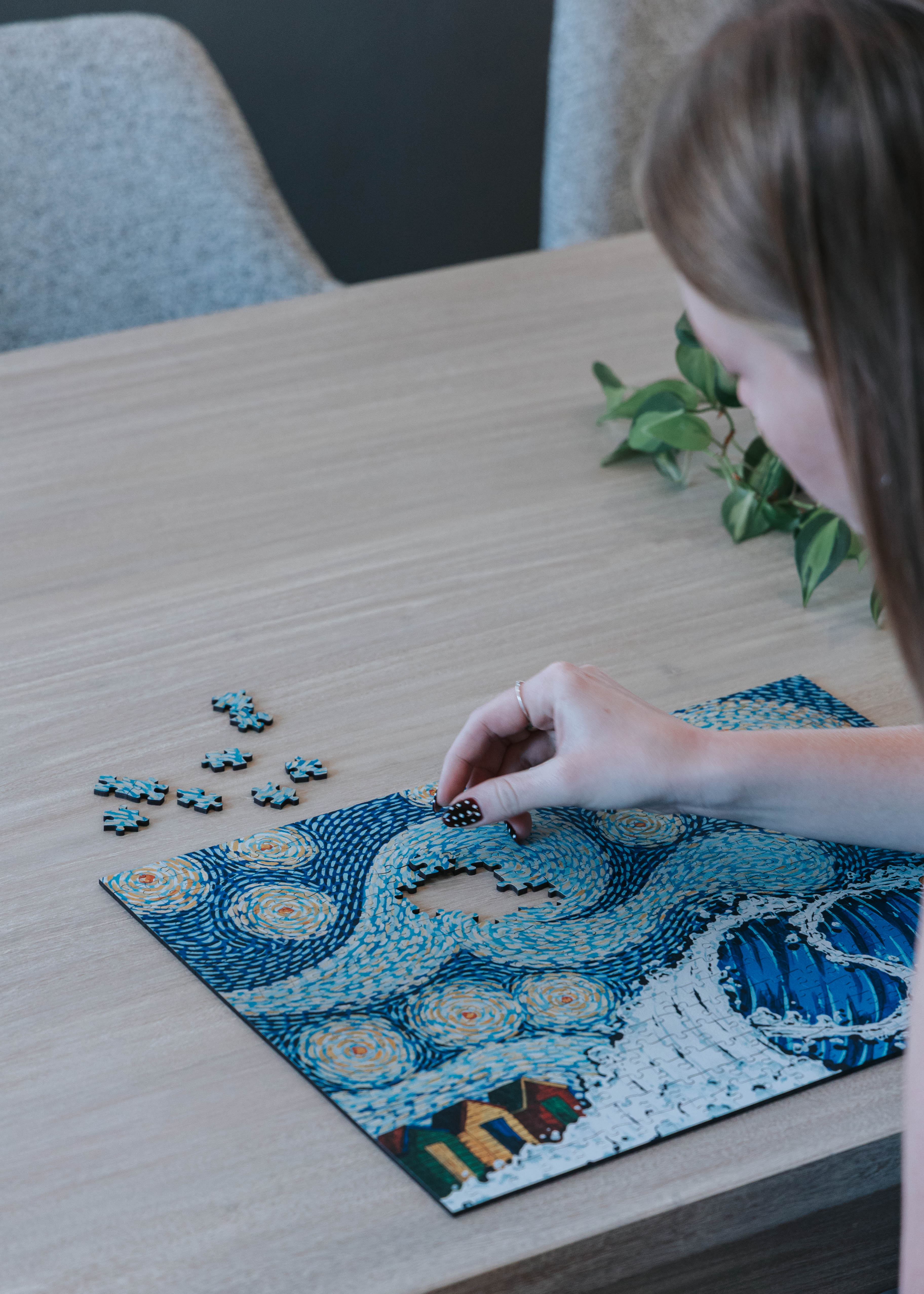 Person working on Starry Night 3mm luxury wooden MasterPiece Puzzle.