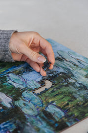 Water Lilies and Japanese Bridge is a&nbsp;MasterPiece wooden jigsaw puzzle&nbsp;of one of Claude Monet’s iconic paintings. This is an Impressionist masterpiece portraying his garden in Giverny. The painting features a serene pond covered in floating water lilies, with a softly arched Japanese bridge overhead.&nbsp;

Precision-cut from 3mm wood and expertly printed, our MasterPiece puzzles offer a tactile and satisfying puzzling experience like no other. They are perfect for&nbsp;classic&nbsp;art lovers&nbs
