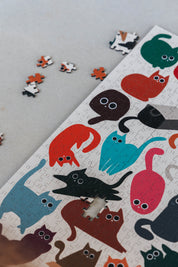 Curious Cats is a MasterPiece wooden jigsaw puzzle featuring a delightful collection of curious cats in various poses and playful scenes. This charming puzzle is a must-have for cat lovers! Precision-cut from 3mm thick wood and expertly printed, our MasterPiece puzzles offer a tactile and satisfying puzzling experience like no other. like no other. This puzzle is perfect for 'crazy cat ladies', art lovers and anyone looking for a thoughtful gift.