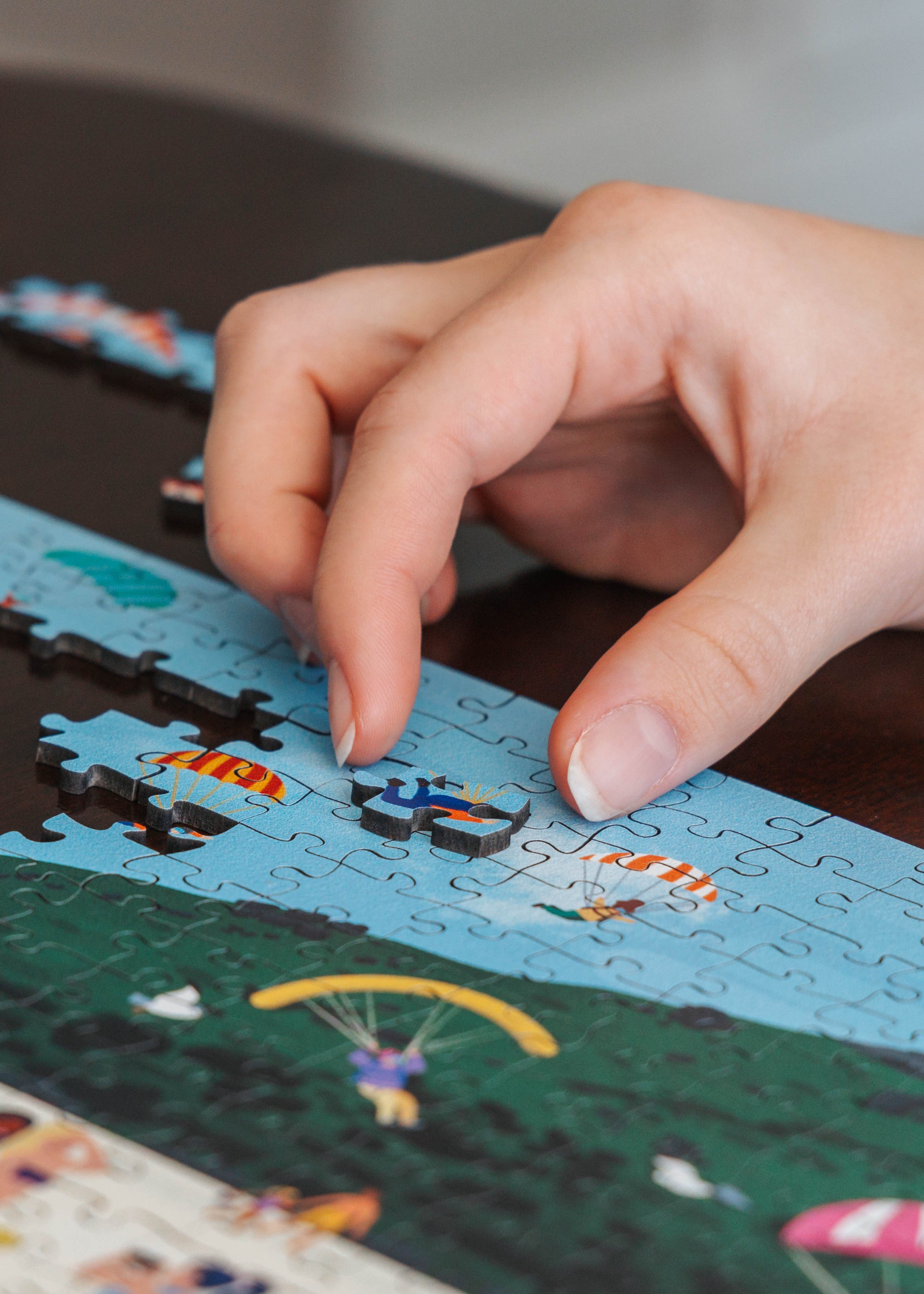 Person working on a puzzle with a scenic design of Camps Bay Beach