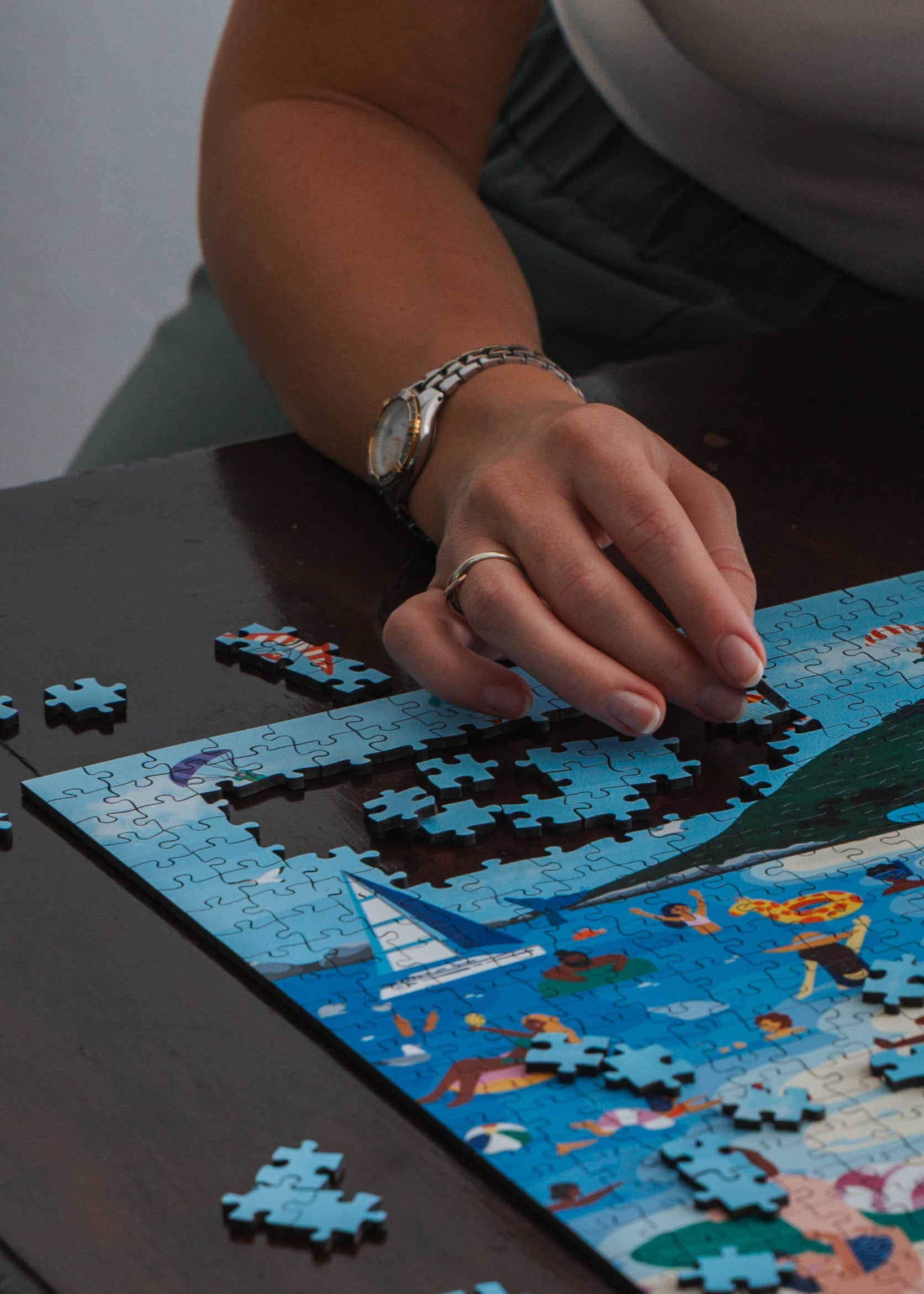 Person working on a puzzle at a table 