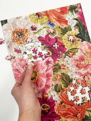 Floral puzzle with a hand placing a piece on a white background