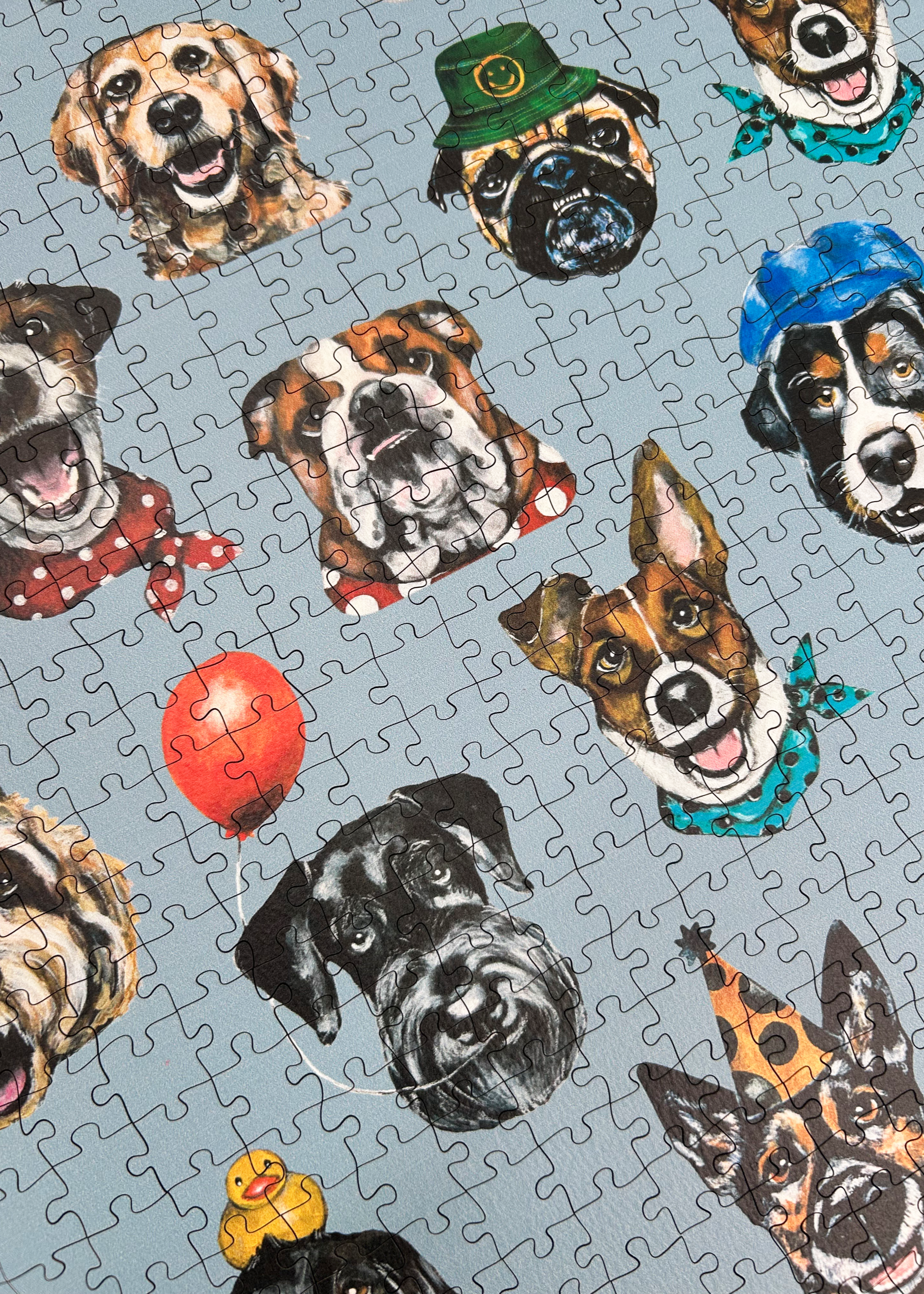 Wooden jigsaw puzzle with dog-themed pieces on a blue background