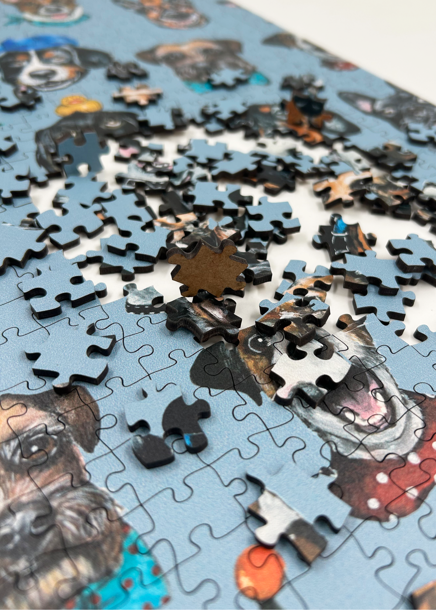 Wooden jigsaw puzzle with dog-themed pieces on a blue background