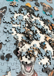 Wooden jigsaw puzzle with dog-themed pieces on a blue background