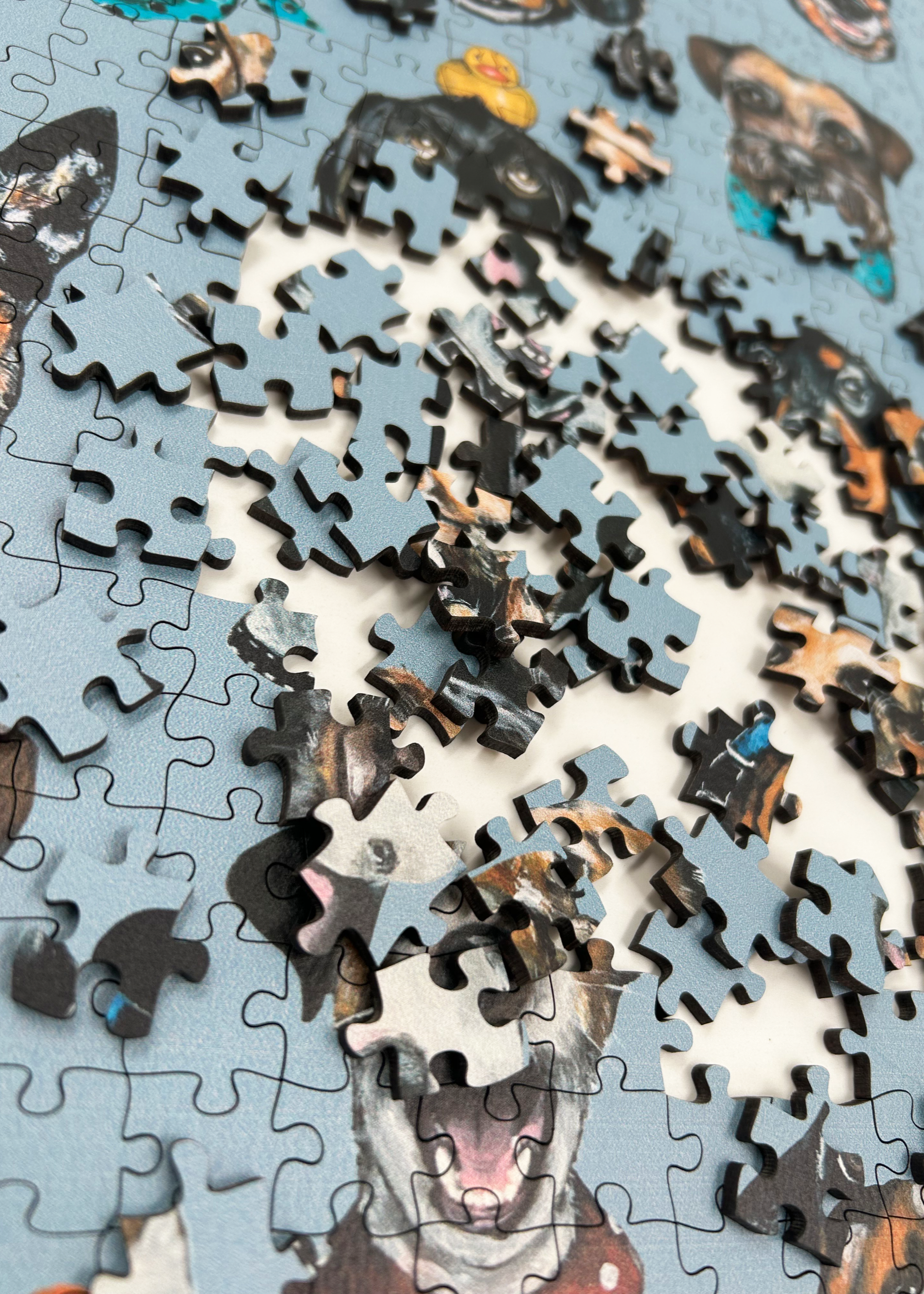 Wooden jigsaw puzzle with dog-themed pieces on a blue background