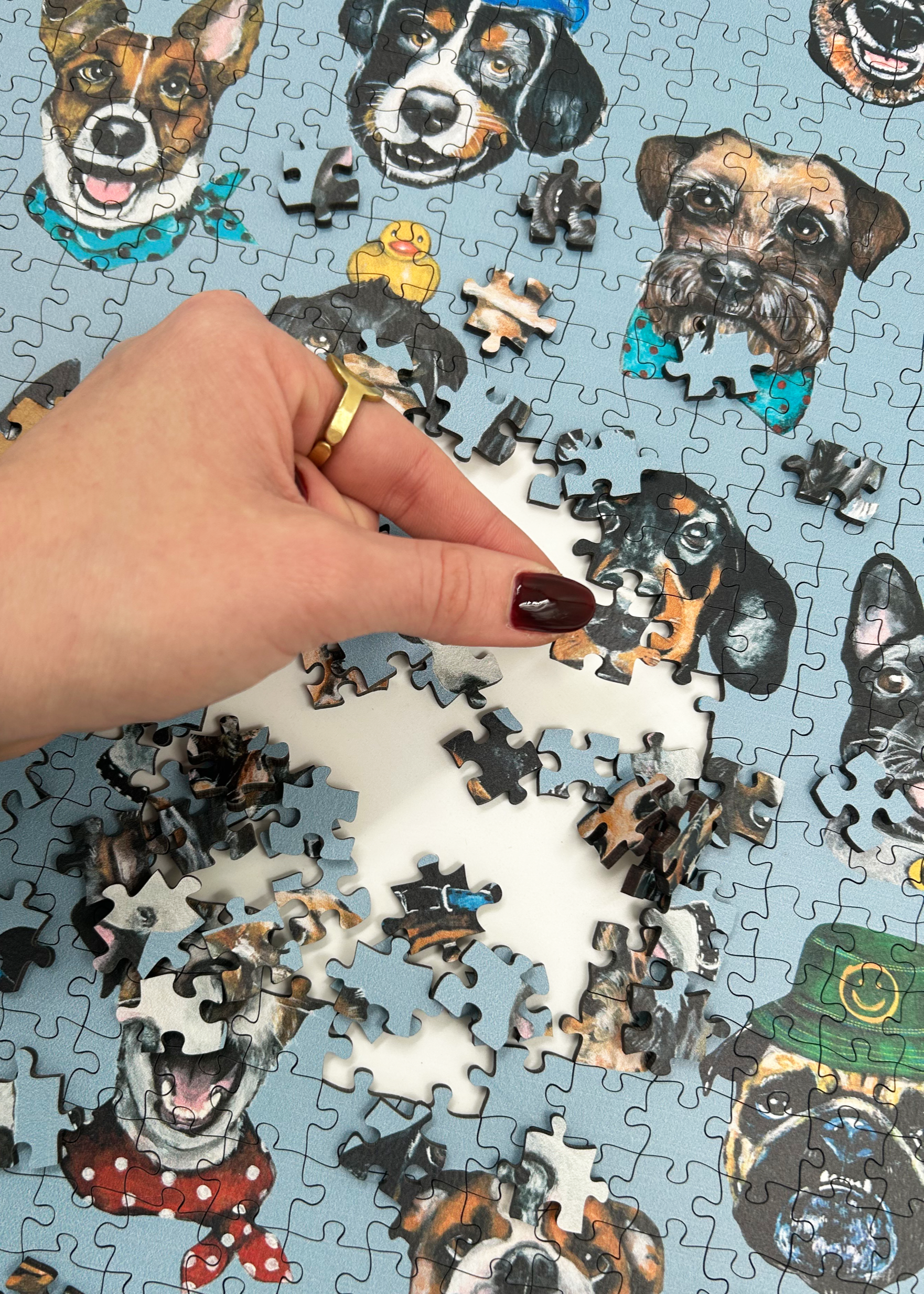 Wooden jigsaw puzzle with dog-themed pieces on a blue background