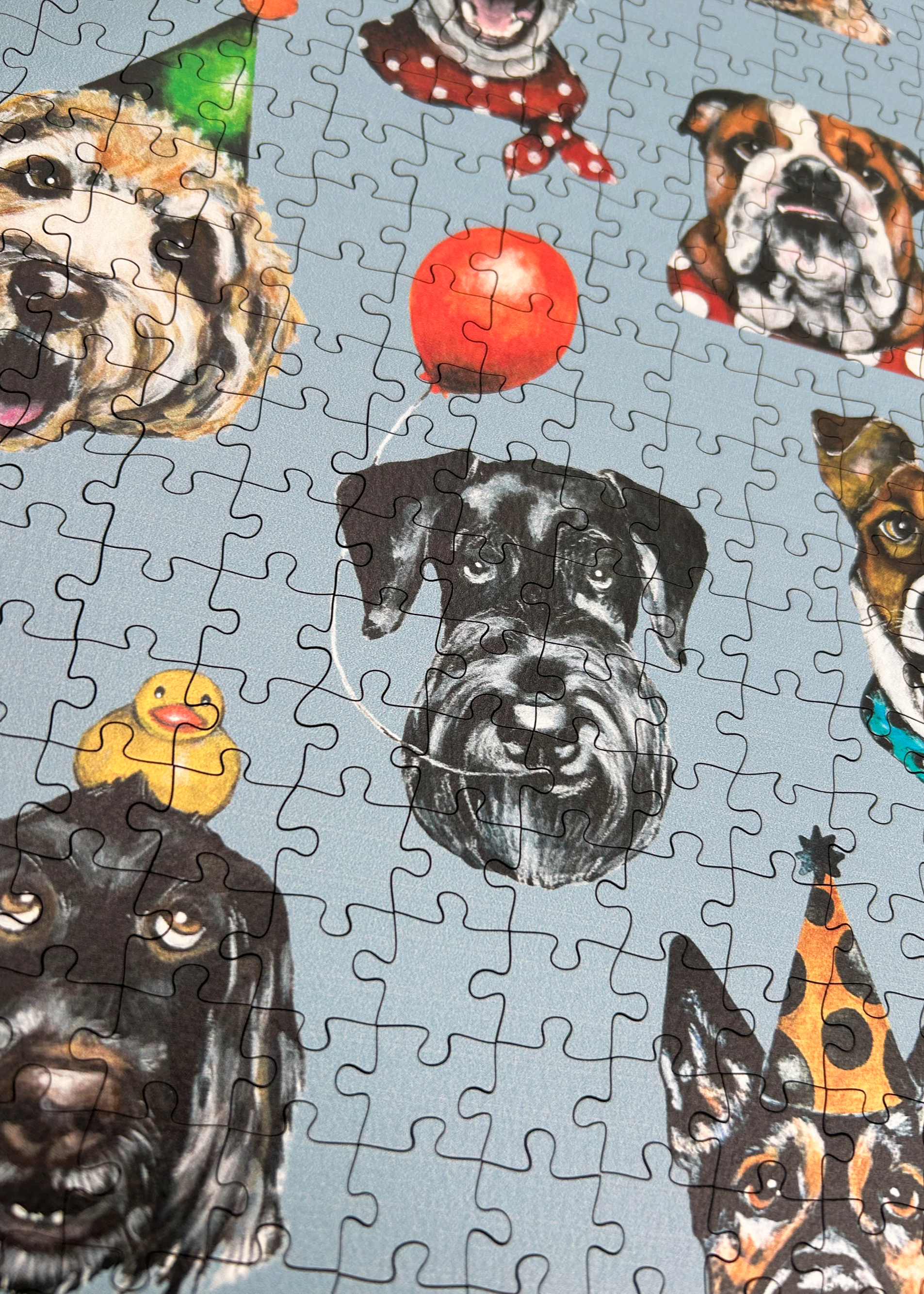 Wooden jigsaw puzzle with dog-themed pieces on a blue background