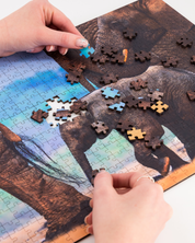MasterPiece luxury wooden puzzle of a South African wildlife photograph of an elephant calf with other elephants taken by Hendri Venter. A way to disconnect, relieve stress and a great gift idea.