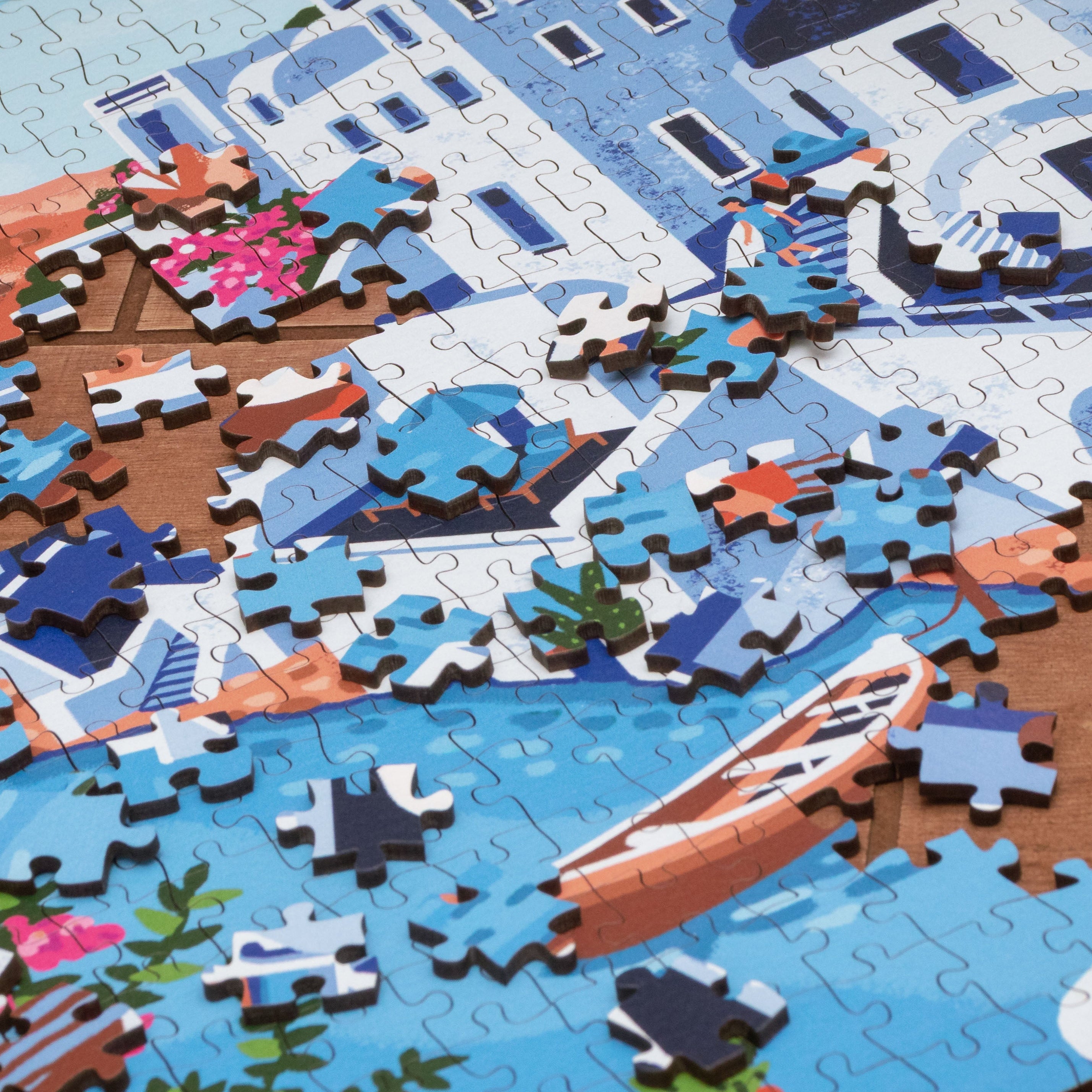 Jigsaw puzzle of a scenic layout with boats and buildings on a wooden surface