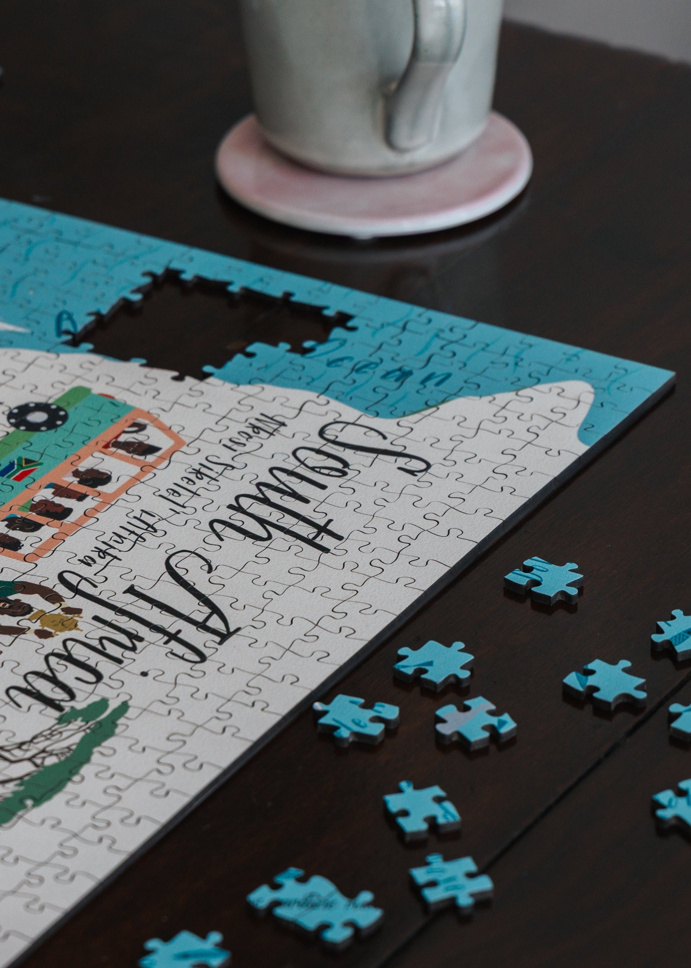 Jigsaw puzzle with completed pieces on a table, featuring animals and text.