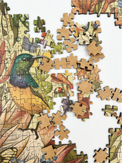 Fynbos Symphony is a MasterPiece wooden jigsaw puzzle that features a stunning nature-inspired illustration that is rich with diverse flora and fauna. Soft, earthy tones create a vintage botanical aesthetic, while vibrant birds and delicate insects bring the scene to life. Precision-cut from 3mm thick wood and expertly printed, our MasterPiece puzzles offer a tactile and satisfying puzzling experience like no other. They are perfect for art lovers, bird lovers and anyone looking for a thoughtful gift.