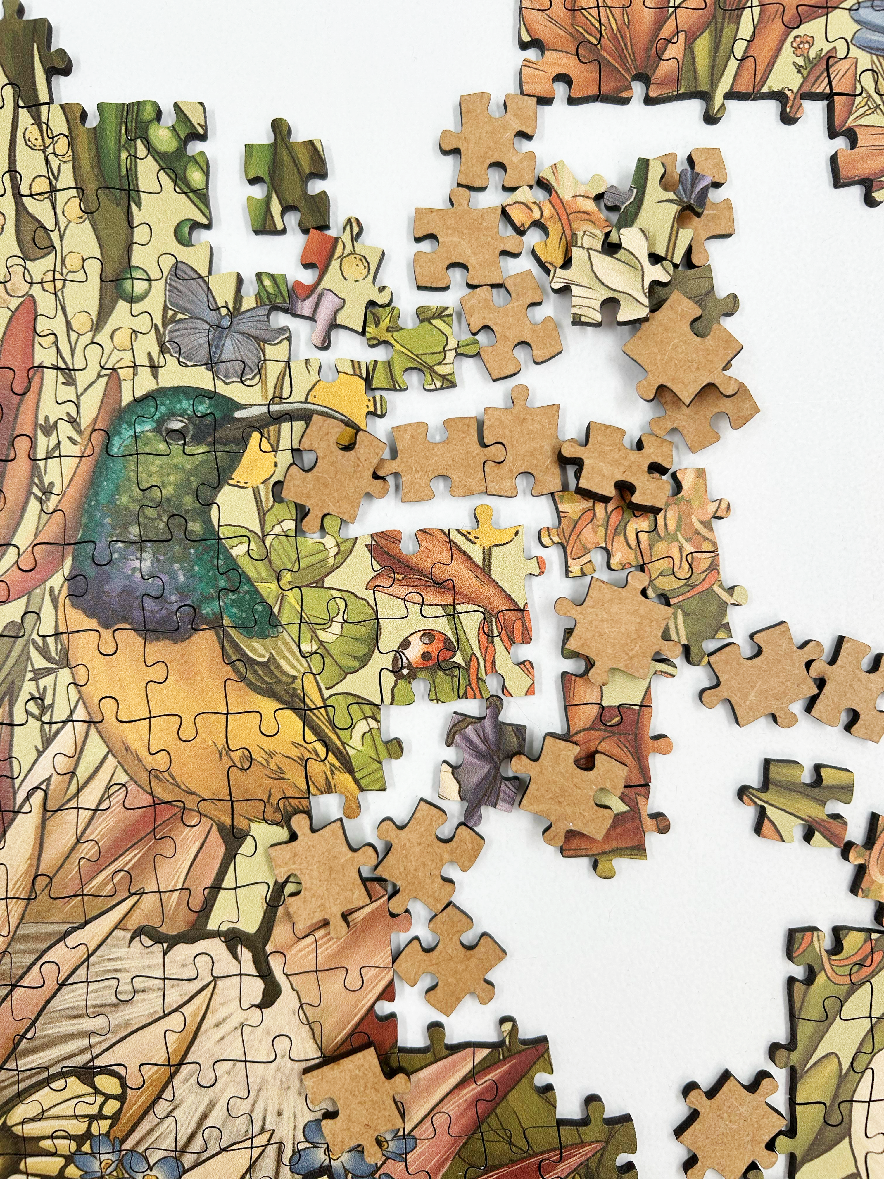 Fynbos Symphony is a MasterPiece wooden jigsaw puzzle that features a stunning nature-inspired illustration that is rich with diverse flora and fauna. Soft, earthy tones create a vintage botanical aesthetic, while vibrant birds and delicate insects bring the scene to life. Precision-cut from 3mm thick wood and expertly printed, our MasterPiece puzzles offer a tactile and satisfying puzzling experience like no other. They are perfect for art lovers, bird lovers and anyone looking for a thoughtful gift.