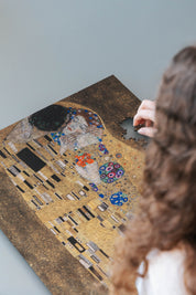 The Kiss is a MasterPiece wooden jigsaw puzzle of one of Gustav Klimt’s most celebrated paintings. This artwork of the Golden Period portrays an intimate embrace between two lovers, enveloped in a shimmering golden cloak adorned with intricate patterns. 

Precision-cut from 3mm thick wood and expertly printed, our MasterPiece puzzles offer a tactile and satisfying puzzling experience like no other. They are perfect for classic art lovers and anyone looking for a thoughtful gift.