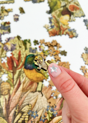 Fynbos Symphony is a MasterPiece wooden jigsaw puzzle that features a stunning nature-inspired illustration that is rich with diverse flora and fauna. Soft, earthy tones create a vintage botanical aesthetic, while vibrant birds and delicate insects bring the scene to life. Precision-cut from 3mm thick wood and expertly printed, our MasterPiece puzzles offer a tactile and satisfying puzzling experience like no other. They are perfect for art lovers, bird lovers and anyone looking for a thoughtful gift.