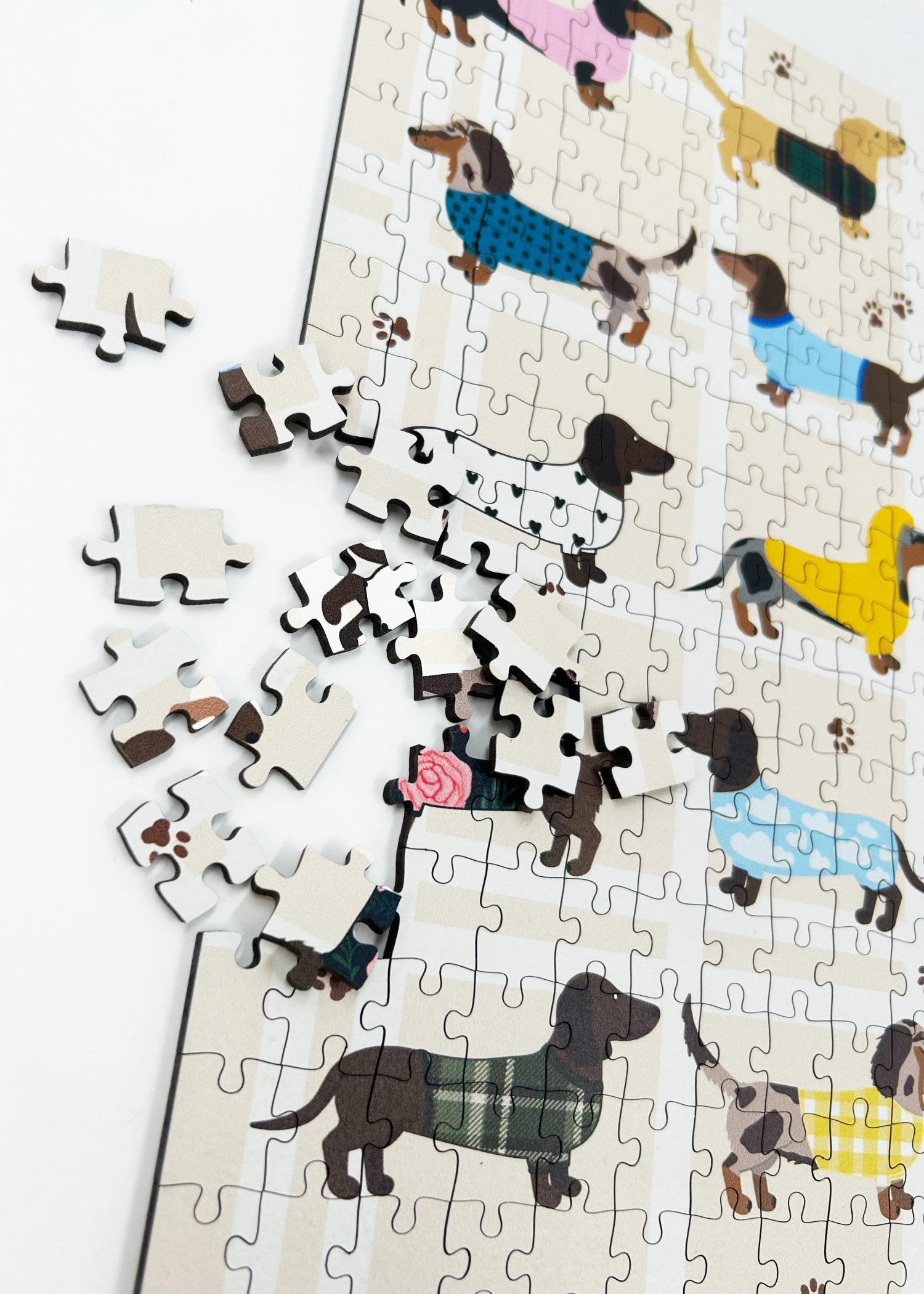 Stylish Sausages is a MasterPiece wooden jigsaw puzzle featuring an adorable line-up of sausage dogs strutting their stuff in various colourful jerseys and scarves, a must-have for dachshund lovers!

Precision-cut from 3mm thick wood and expertly printed, our MasterPiece puzzles offer a tactile and satisfying puzzling experience like no other. This puzzle is perfect for dachshund lovers and anyone looking for a thoughtful gift. 