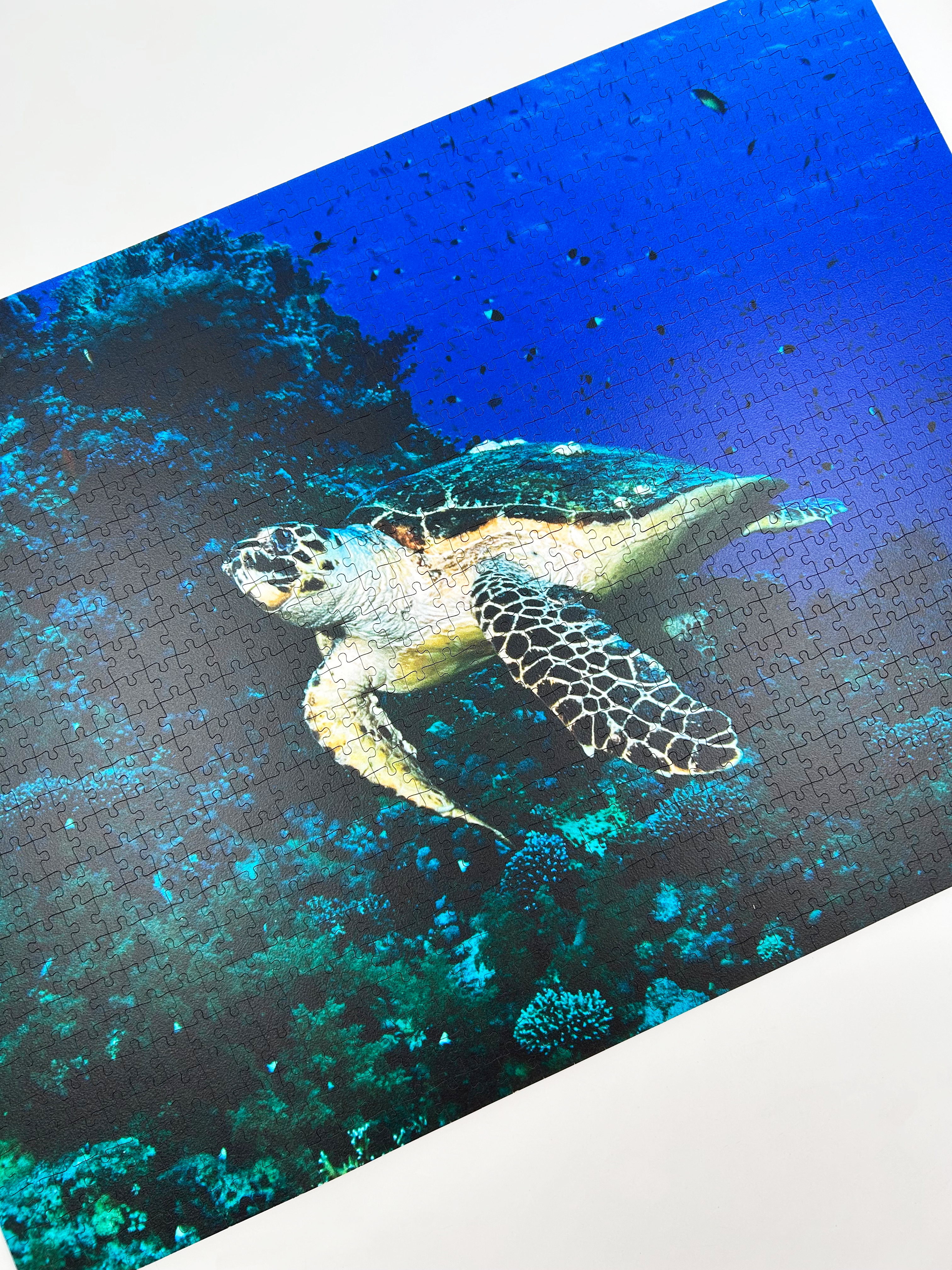 Turtle is a MasterPiece wooden jigsaw puzzle that features a beautiful underwater photograph of a turtle swimming in front of a coral reef.

Precision-cut from 3mm wood and expertly printed, our MasterPiece puzzles offer a tactile and satisfying puzzling experience like no other. They are perfect for ocean lovers, nature enthusiasts and anyone looking for a thoughtful gift.