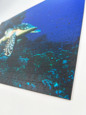 Turtle is a MasterPiece wooden jigsaw puzzle that features a beautiful underwater photograph of a turtle swimming in front of a coral reef.

Precision-cut from 3mm wood and expertly printed, our MasterPiece puzzles offer a tactile and satisfying puzzling experience like no other. They are perfect for ocean lovers, nature enthusiasts and anyone looking for a thoughtful gift.