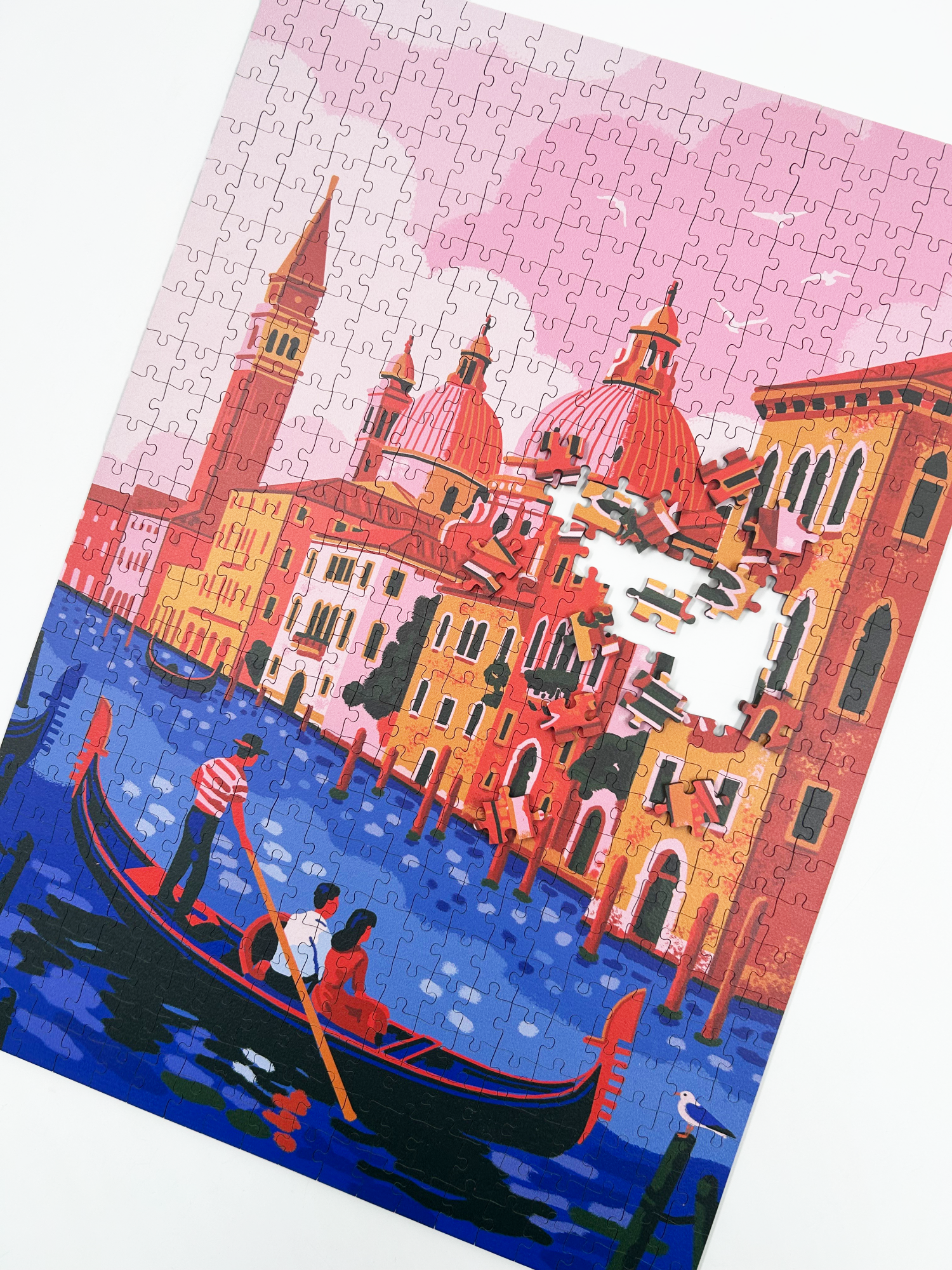 Venice is a MasterPiece wooden jigsaw puzzle featuring an illustration with an iconic gondola, pastel buildings and a dreamy pink sky. Soft hues of pink, orange and blue beautifully capture the romantic charm of Italy’s floating city.

Precision-cut from 3mm thick wood and expertly printed, our MasterPiece puzzles offer a tactile and satisfying puzzling experience like no other. This puzzle is perfect for art lovers, travellers and anyone looking for a thoughtful gift.