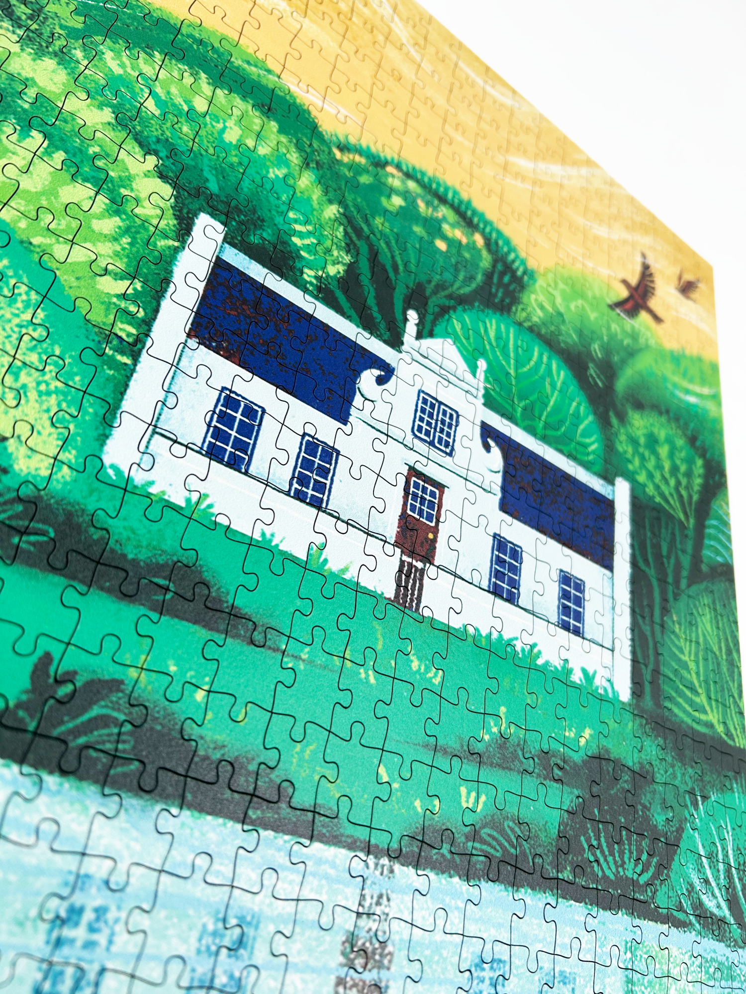 A wooden jigsaw puzzle featuring an illustration of the Zevenwacht Wine Estate manor house. Perfect for art lovers and anyone looking for a thoughtful gift. 